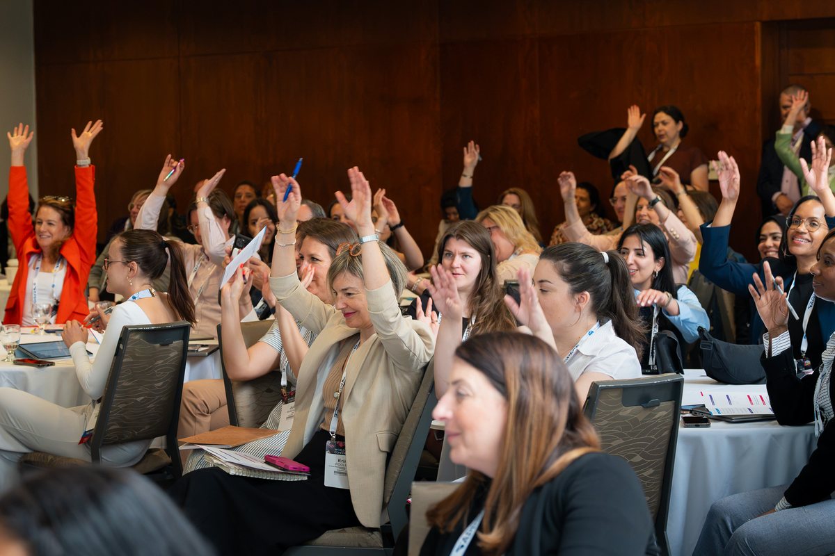 Attendees raising their hands during Communications in Motion