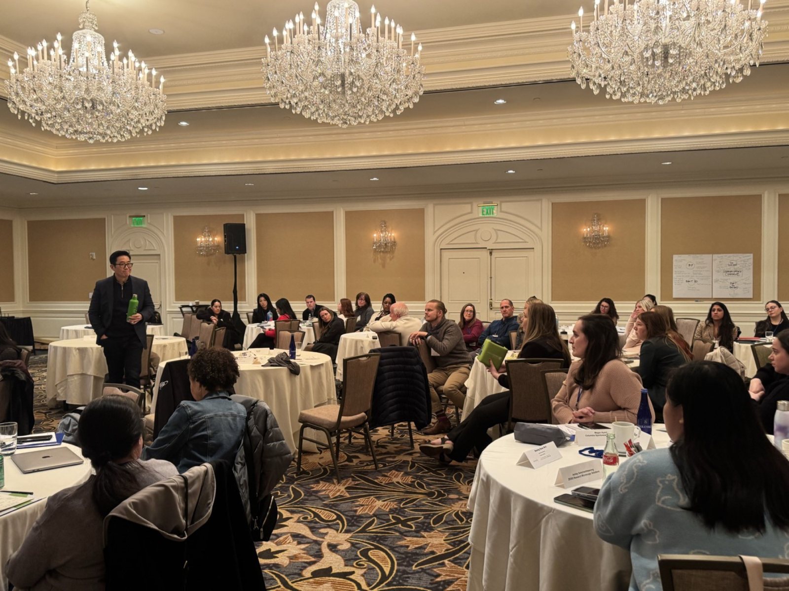 A host among the round tables in the ballroom at ALI San Francisco 2025