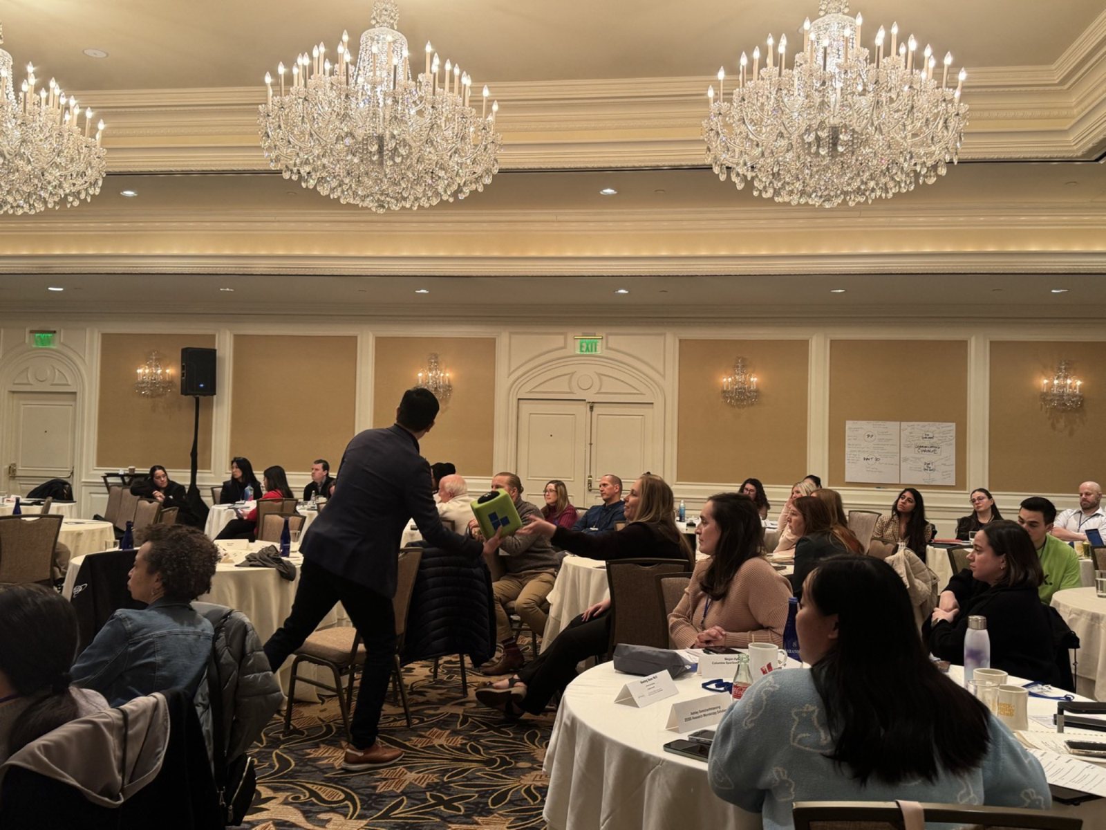 A host moving through the audience during the table discussion