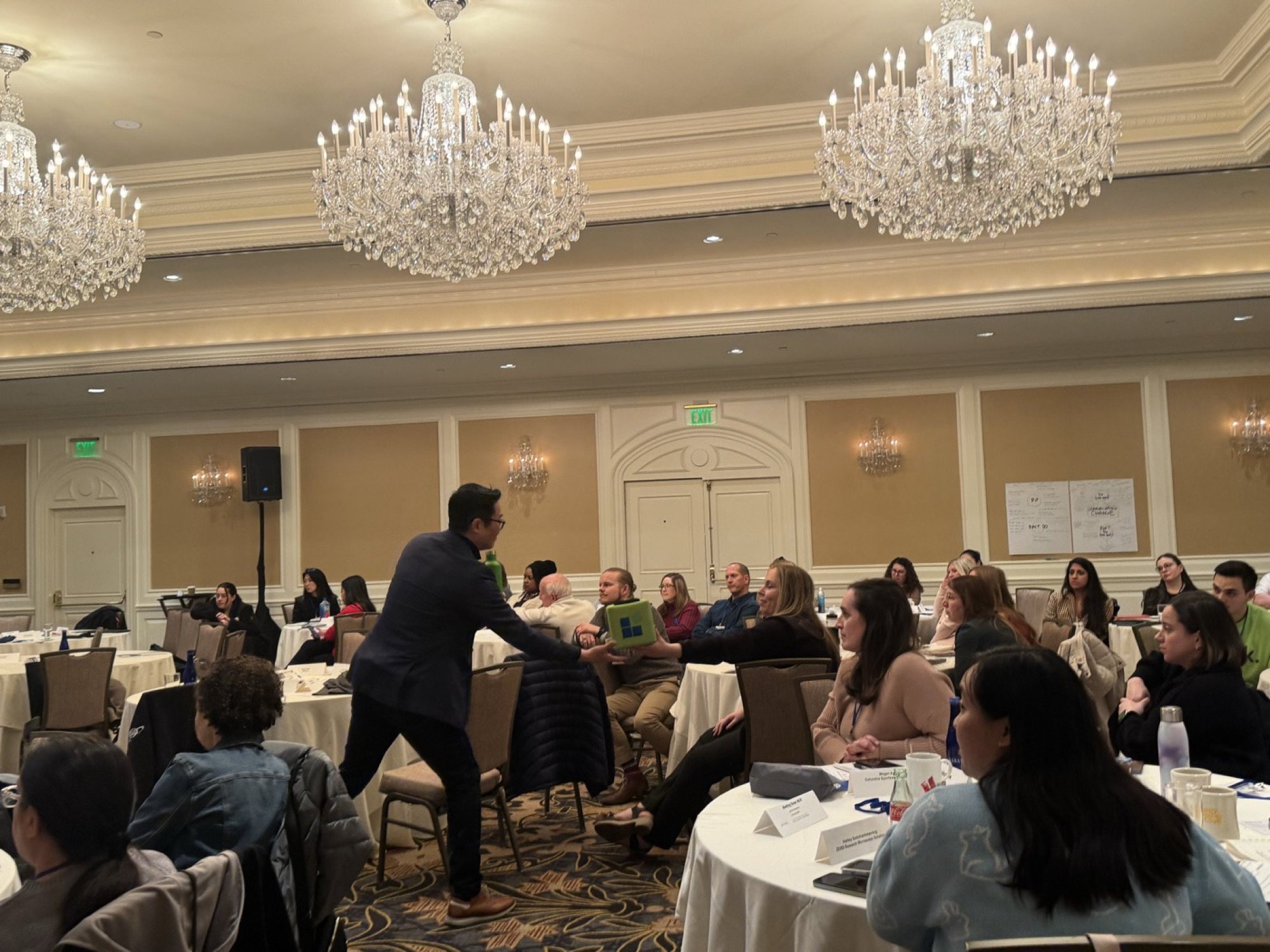 A host moving among the round tables during the un-panel at ALI San Francisco 2025