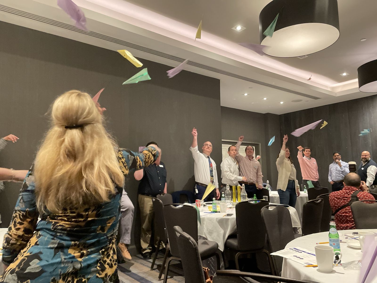 Attendees throwing paper airplanes across the room