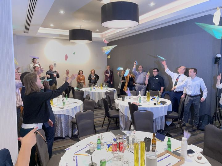 Paper airplanes flying across a room during Paper Airplanes and Ideas that Fly