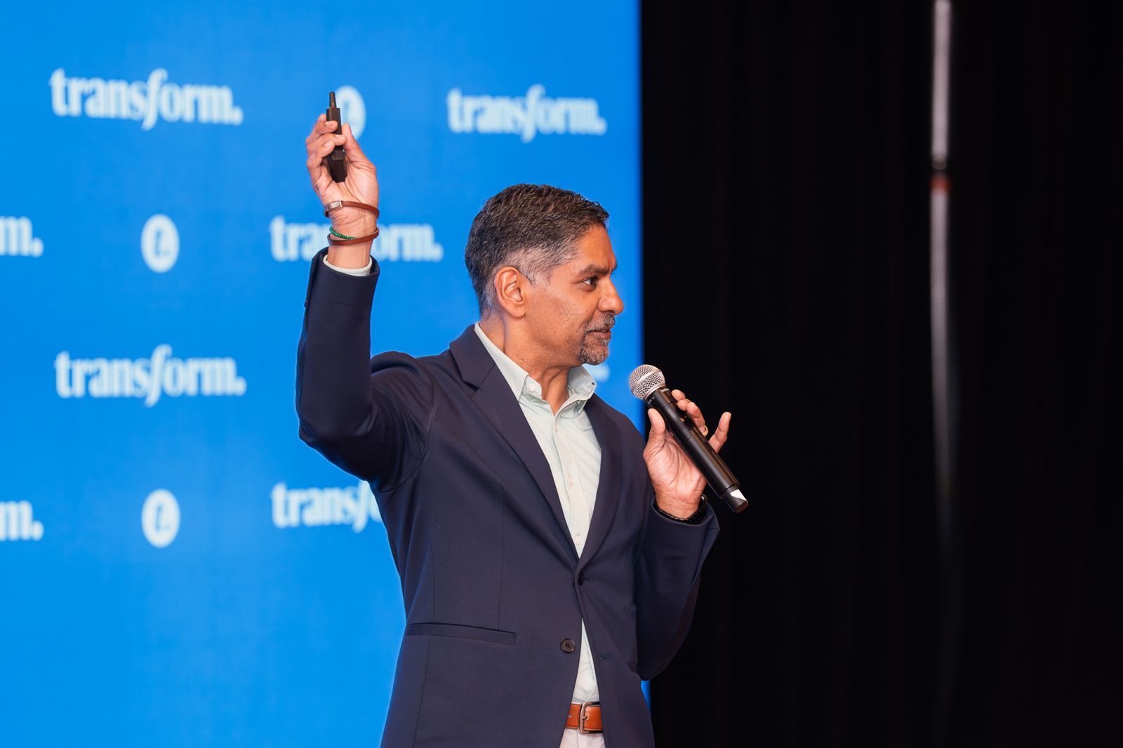 Pinaki Kathiari gesturing with the slide clicker raised